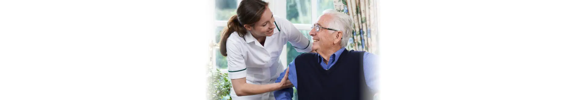 Care Worker Helping Elderly Patient To Get Up Out Of Chair